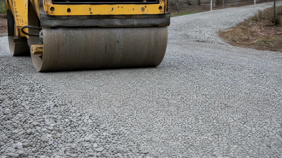 Roller compacting a crushed stone driveway