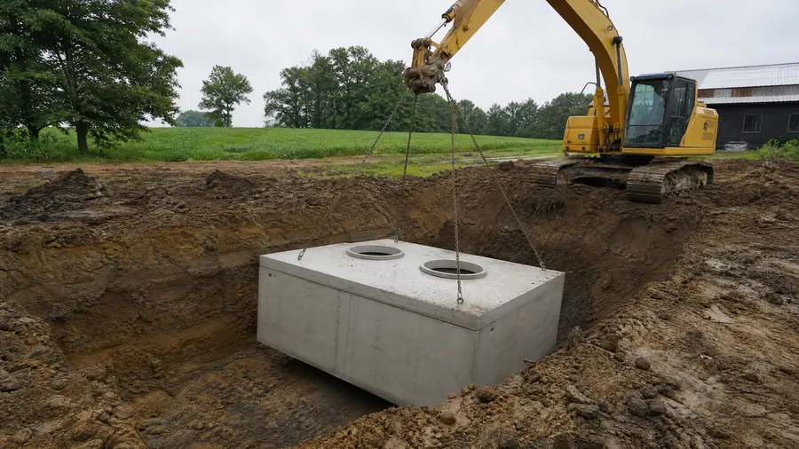 Septic tank being placed by excavator